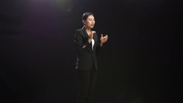 Speaker Woman Clapping Her Hands And Looking Around While Standing In The Black Studio