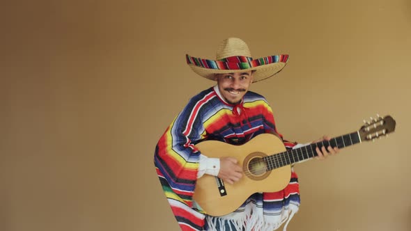 Young Mexican In National Costume Playing Guitar