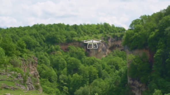 a White Drone Flies Over the Mountains and Shoots a Video