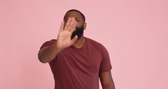 Young African American Man Disagree Show Thumb Down on Pink Background