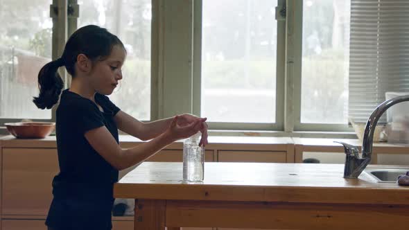 Corona pandemic - Young girl using hand sanitizer to prevent coronavirus spread