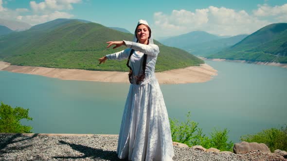 A Girl in a Georgian National White Dress is Dancing