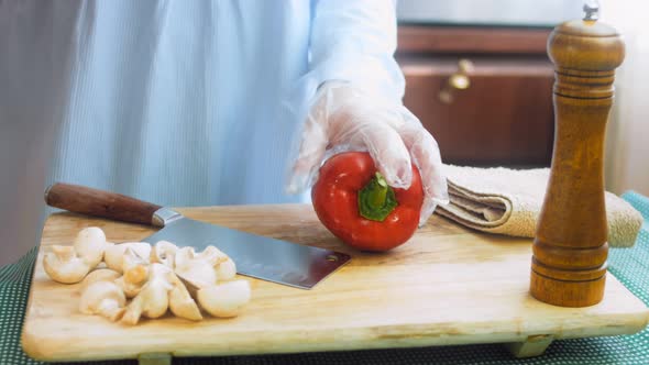 The Chef Cuts a Sweet Red Pepper in Half with a Professional Knife