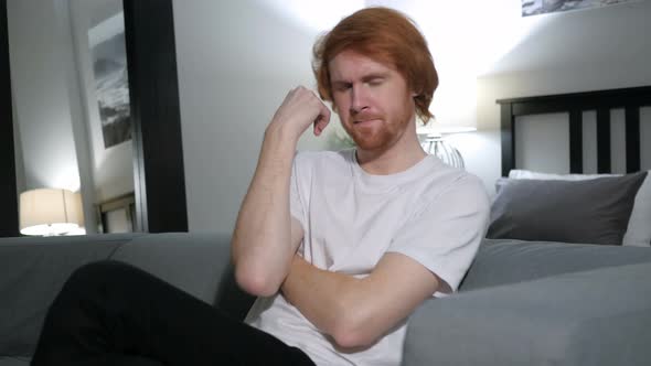 Redhead Man Sleeping while Sitting on Couch in Bedroom