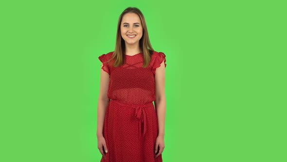 Tender Girl in Red Dress Is Smiling While Looking at Camera. Green Screen