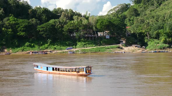 Long-tail boat moving at the current at the Mekong river in Luang Prabang