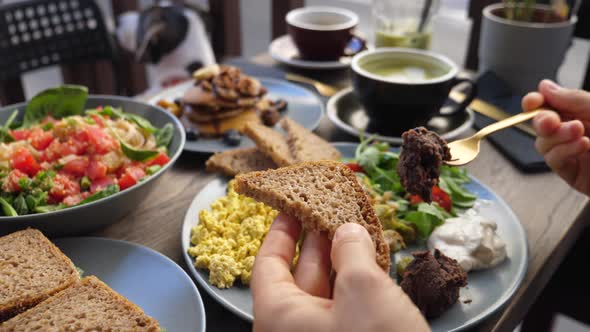 Hands Spreading Dips on Piece of Brown bread.Healthy Balanced Vegan Brunch.