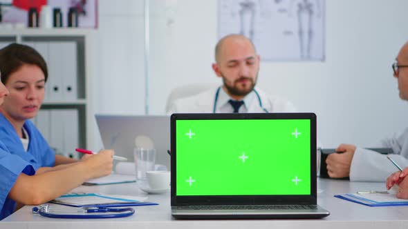 Team of Doctors Placing Laptop with Green Screen in Front of Camera