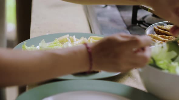 Serving salad on plate with chicken, pasta and sauce