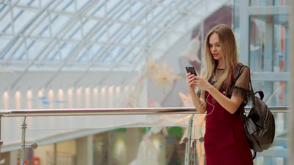 Portrait of Cheerful Teen Girl Enjoying Music in Stereo Accessory Connected To Smartphone