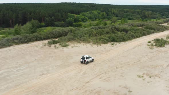 Aerial View of a Car Driving on Sand