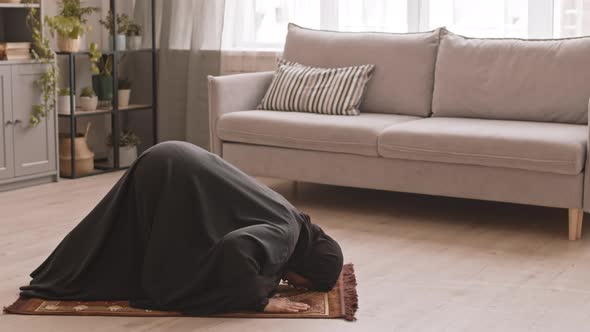 Muslim Woman in Black Praying at Home