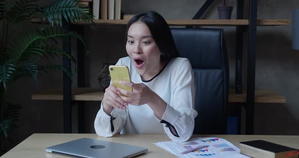 Excited Young Asian Lady User Winner Hold Smartphone Feel Amazed with Good Surprise Social Media