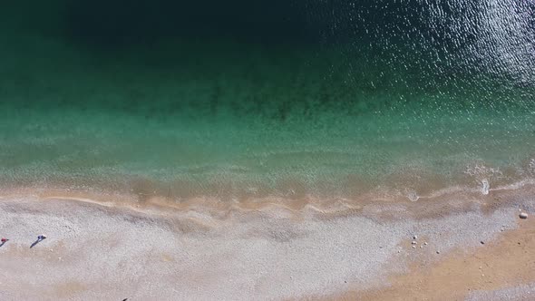 Aerial View From Above on Azure Sea and Pink Pebbles Beach