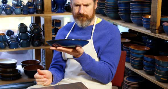 Male potter examining a earthenware bowl