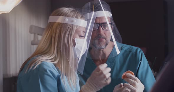 Professional Dental Specialist in Masks Discussing Patient Jaw