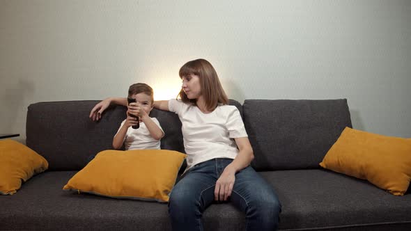 Happy Family  Mother Her Little Son Watching TV Living Room