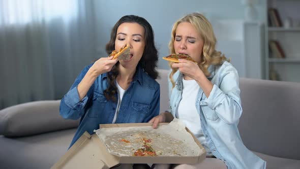 Two Female Friends Eating Pizza at Home, Leaving Last Piece in Box, Girls Party