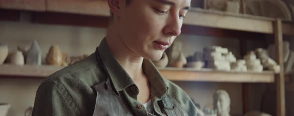 Female Sculptor Working with Clay and Taking Break