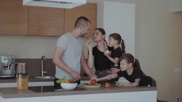 Happy Young Family with Mum Dad with Two Daughters Cut Vegetables for Salads and Treat Each Other