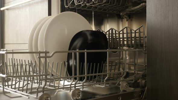 Dish washing machine basket close-up 4K 2160p 30fps UltraHD footage - Dishware arranging inside buil