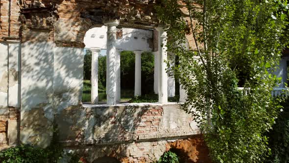 Aerial Drone View Flight Into Arch Between Columns of Old Ruins in Park