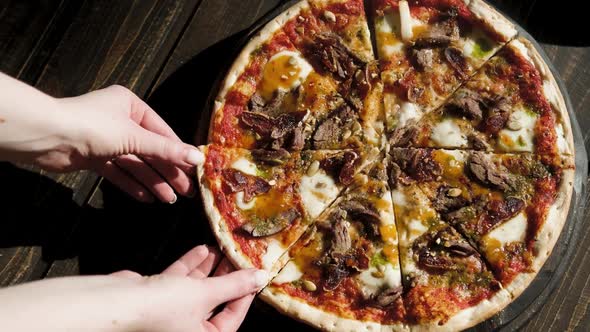 the Girl's Hand Takes a Slice of Pizza Close Up