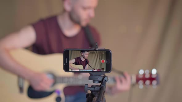 Man Recording Guitar Lessons for Students