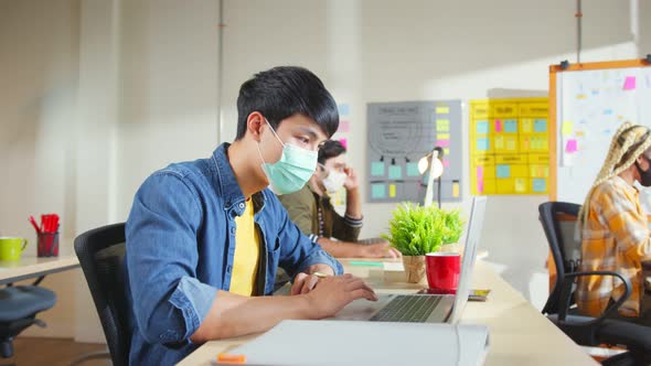 Young creative designer agency in protective face mask for protect pandemic virus working