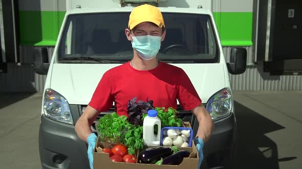 Young Man Deliver Holds Box of Food and Stands on Background of Car Outdoors Spbd.
