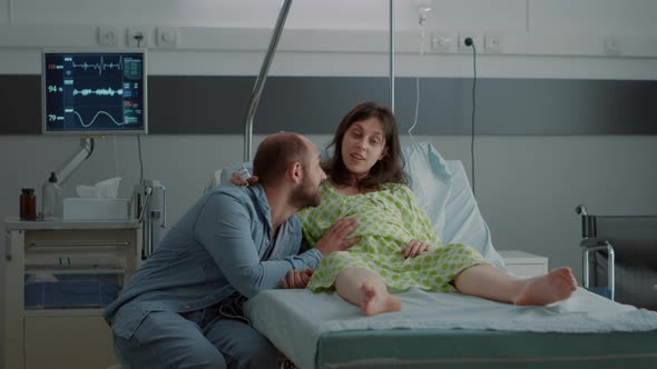 Caucasian Man and Woman Expecting Child in Hospital Ward