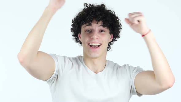 Excited Young Man with Curly Hairs Celebrating Success