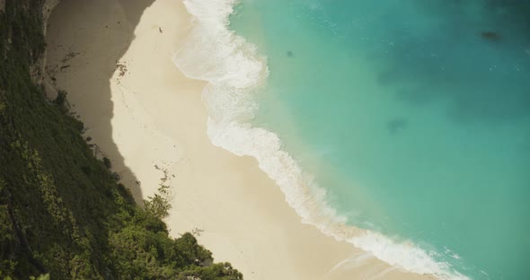 Close Up Slow Motion Shot of Blue Waves Crashing on the Sandy Tropical Beach Overhead Top Down View