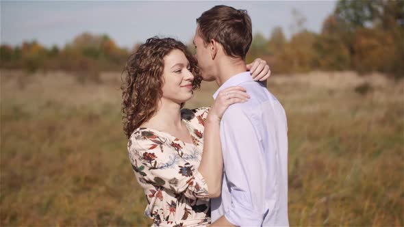 Happy Teenage Couple First Kiss Girl Kissing. Loving Couple Embracing.