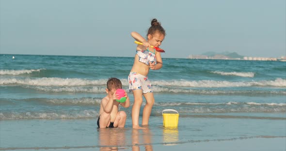 Happy and Carefree Children Playing By the Sea with Sand . Children Playing, Brother and Sister Play