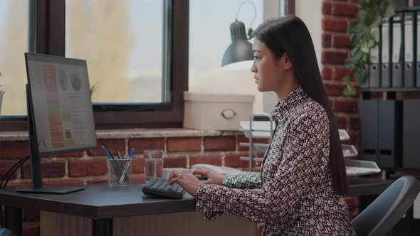 Person Dealing with Backache While She Works on Business Strategy