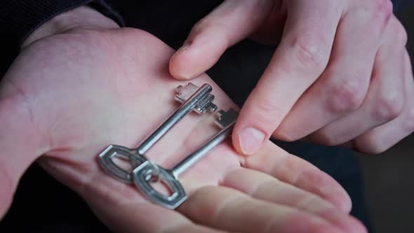 Hand Holding Home Keys and Showing It to the Camera Closeup