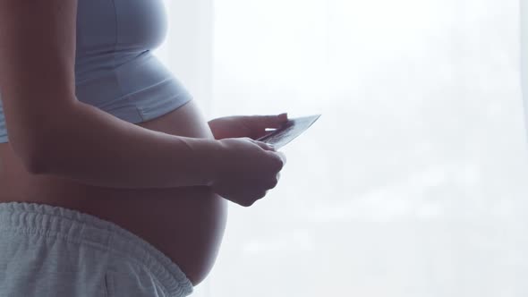 Young pregnant woman is resting at home and expecting a baby.