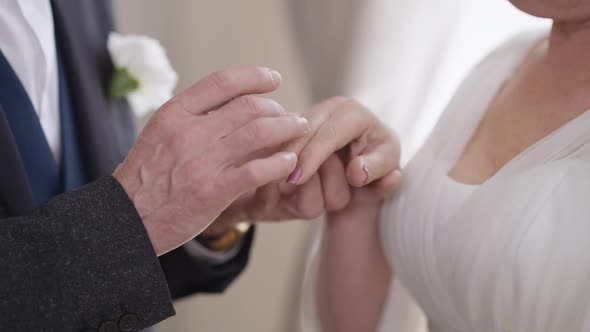 Closeup Senior Male Hand Putting Wedding Ring on Female Palm in Slow Motion