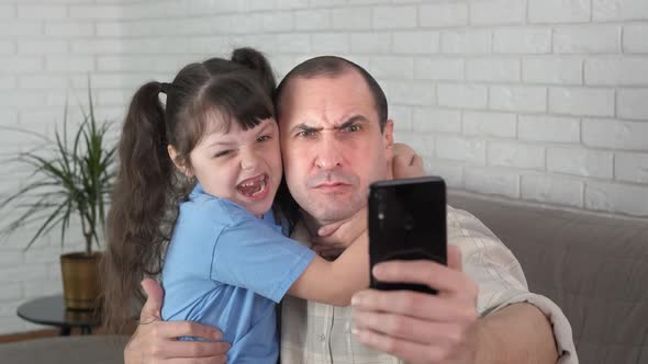 Child and dad are taking a selfie. 