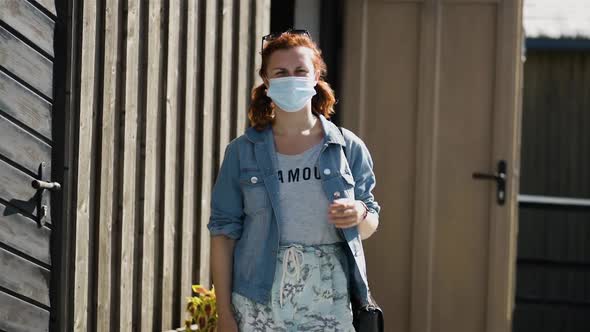 Young Serious Woman Walks To Camera Wearing Rainbow Bracelet and Medical Face Mask at Cafe During