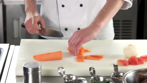 Hands of Chef Chopping Carrot
