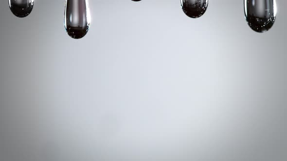 Super Slow Motion Macro Shot of Dripping Oily Liquid on Dark Grey Background at 1000 Fps alt