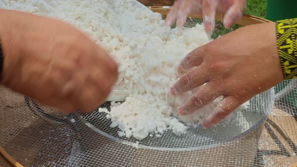 Sifting cassava flour into a pot to make a traditional crepe bread called "beiju" by the indigenous