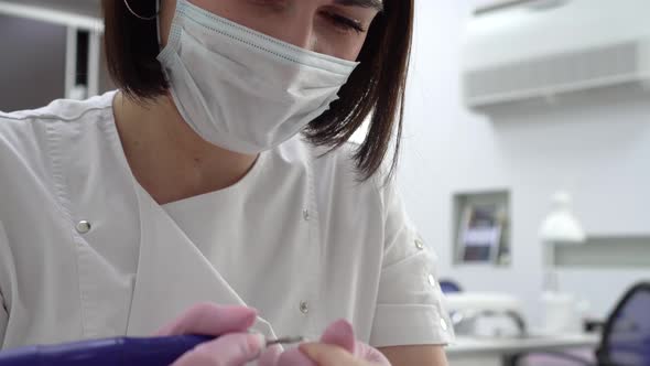 A Professional Manicurist Using a Drill Tool Cuts Off Old Nails Closeup