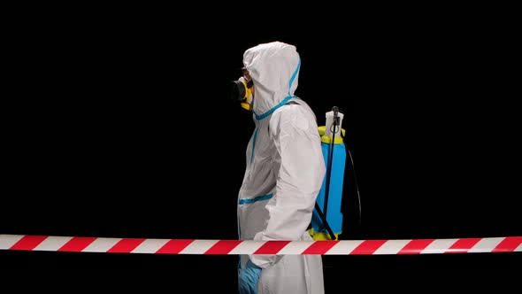 The View From Behind the Signal Tape a Virologist in Protective Uniform Walks and Disinfects the