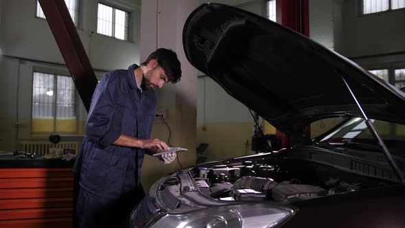 Auto Mechanic Using Tablet Looking for Spare Parts