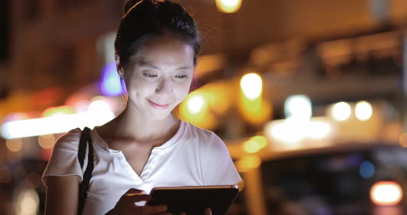 Woman using digital tablet computer at night 