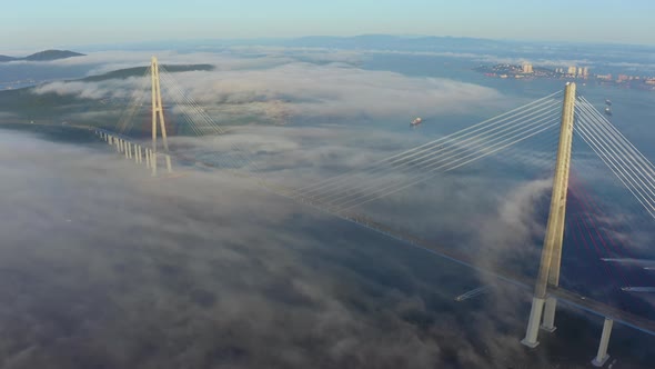 The Pylons of the Giant Cablestayed Bridge Rise Above the Seaside Morning Fog