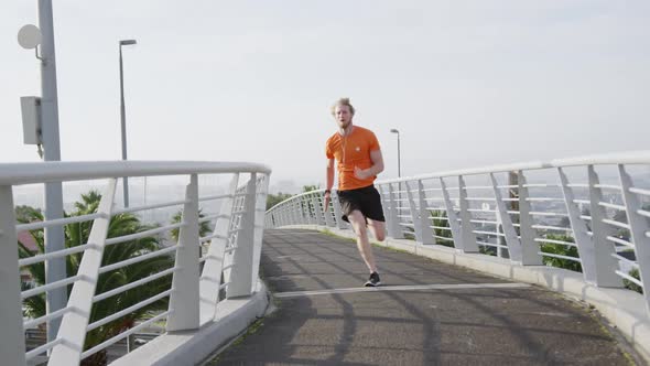 Sporty Caucasian man training on a bridge